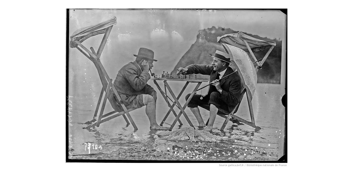 Scnes de plage [2 hommes jouant aux checs les pieds dans l'eau] : [photographie de presse] / [Agence Rol]